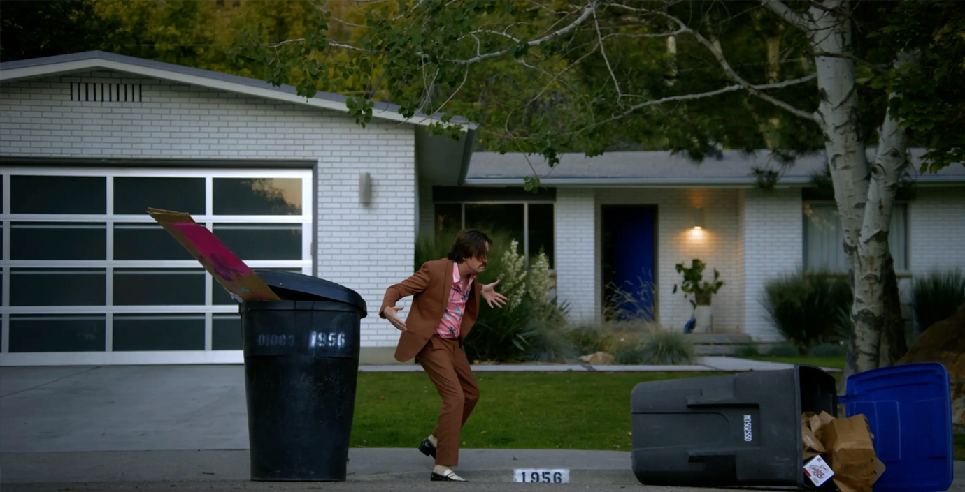 Cole kicking over trash can.