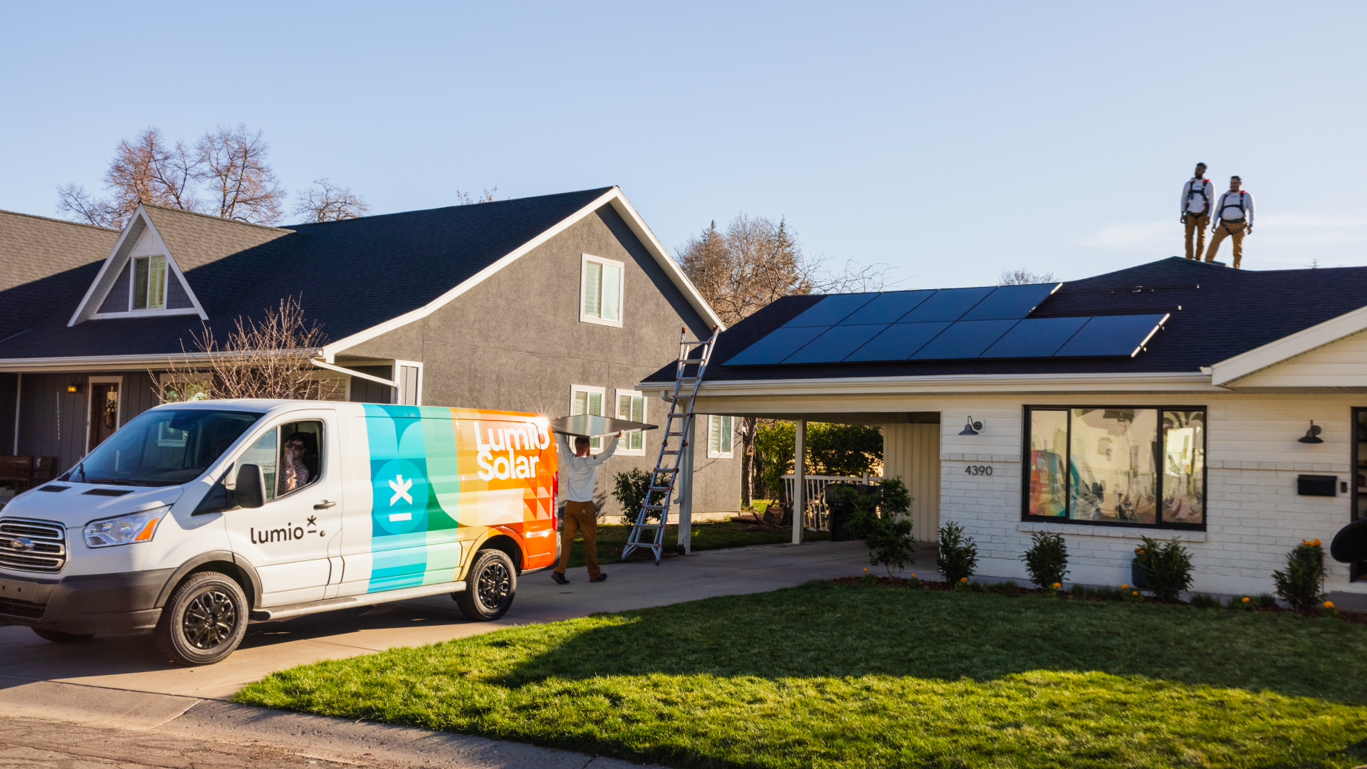 Lumio installers working on a solar panel installation on the roof of a house.